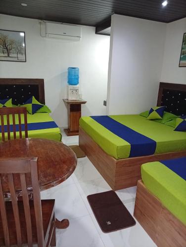a room with two beds and a table in it at Moonlight Resort in Anuradhapura