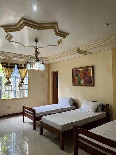 a bedroom with two beds and a chandelier at Brussels Garden Inn in Lagawe