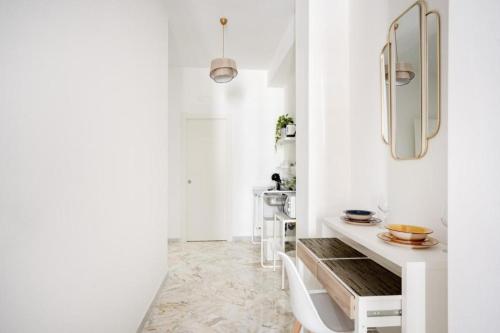 a white room with a table and a mirror at AuGuStea - Modern Central Suites in Bari