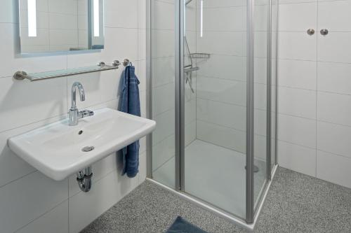 a bathroom with a sink and a shower at Ferienhaus Bellevue in Bensersiel