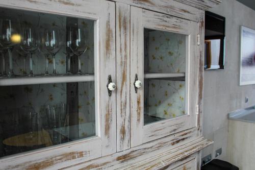 a wooden cabinet with glass doors in a kitchen at Casa Rural Las Bodegas II in Valbuena de Duero