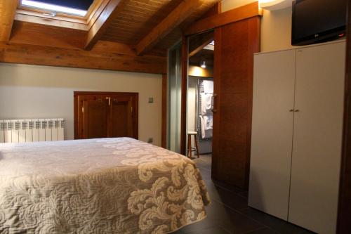 a bedroom with a bed and a flat screen tv at Casa Rural Las Bodegas II in Valbuena de Duero