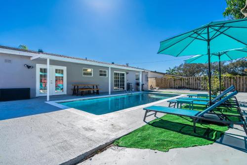a swimming pool with two chairs and an umbrella at Relax & Fun Hollywood Private Pool | Arcade Game in Hollywood