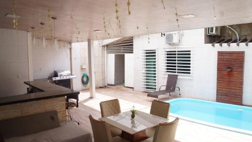 a kitchen and a living room with a swimming pool at Casa compartilhada com Quarto e Suite no Parque 10 in Manaus