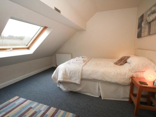 a bedroom with a bed and a window at Cragg Hall View in Mytholmroyd
