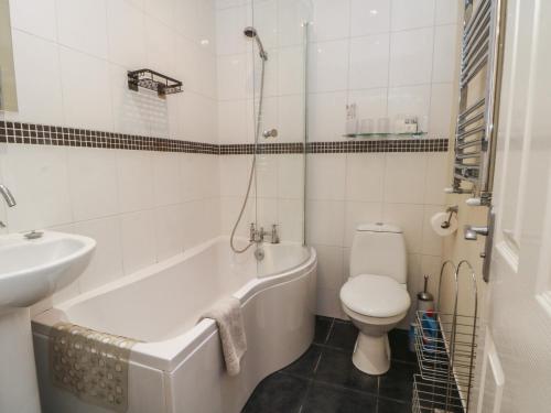 a bathroom with a tub and a toilet and a sink at Cragg Hall View in Mytholmroyd