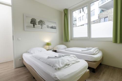 two beds in a room with a window at Dormio Resort Eifeler Tor in Heimbach