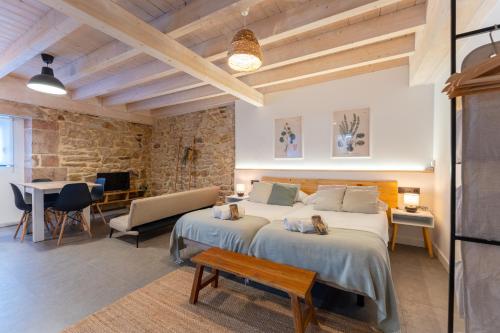 a bedroom with two beds and a table and a desk at Sandoñana Old Palace Lodge in Villafufre