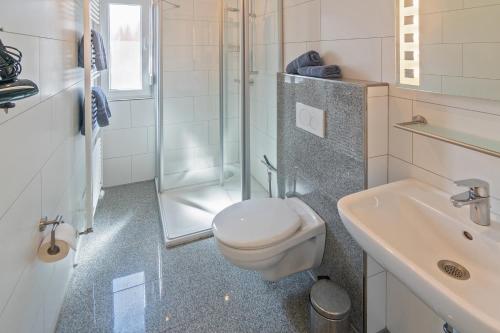 a bathroom with a toilet and a sink and a shower at Ferienwohnung Bel Air in Bensersiel