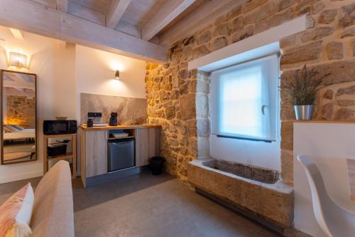 a room with a stone wall and a window at Sandoñana Old Palace Lodge in Villafufre