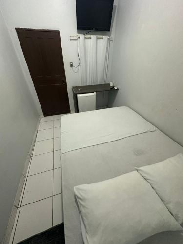 a small room with two beds and a television at Hotel São Cristóvão in Marabá