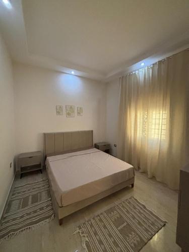 a bedroom with a bed and a large window at Dar Lina in Tozeur