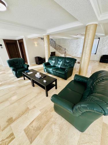 a living room with green couches and a table at Roua Residence in Vladimirescu