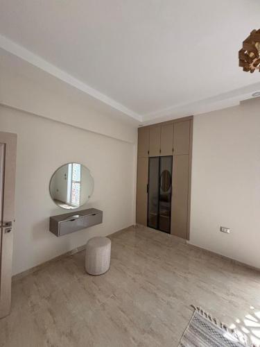 a white room with a mirror and a stool at Dar Lina in Tozeur