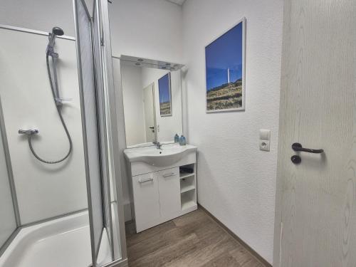 a white bathroom with a sink and a shower at Wohnung mit Balkon in Zwickau