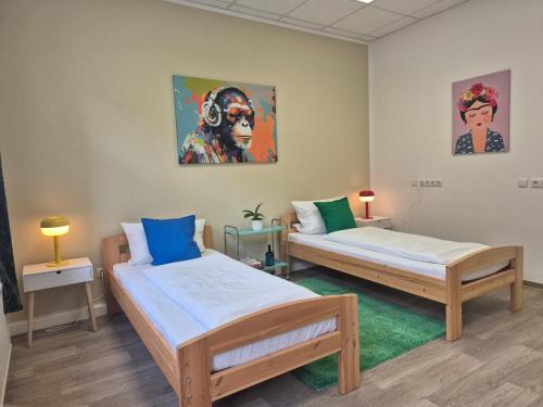 two beds in a room with paintings on the wall at Wohnung mit Balkon in Zwickau