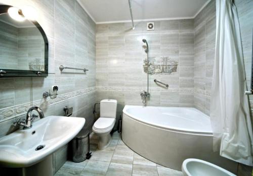 a bathroom with a tub and a toilet and a sink at Едем in Skhidnitsa