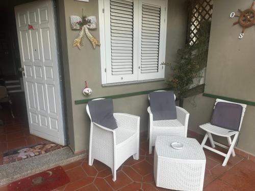 a porch with three chairs and a table and a window at B&B Filomena in Santa Giusta