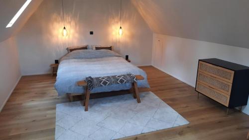 a bedroom with a bed and a dresser in a attic at Gezellig huisje met zwembad en sauna in Ellezelles - Bellezelles in Ellezelles