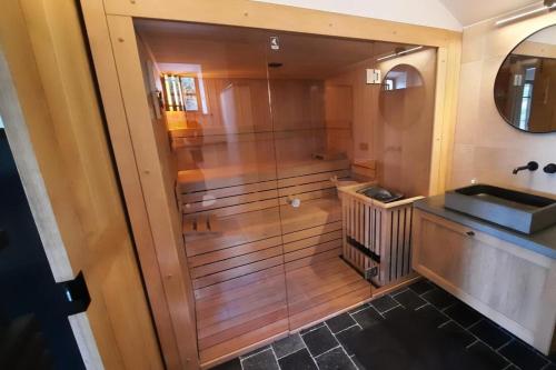 a bathroom with a shower and a sink and a mirror at Gezellig huisje met zwembad en sauna in Ellezelles - Bellezelles in Ellezelles