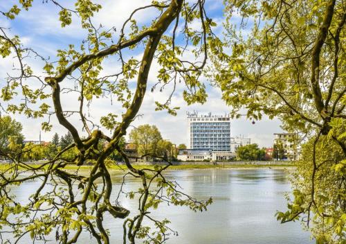 a view of a river with a building in the background at Hotel Magnólia in Piešťany