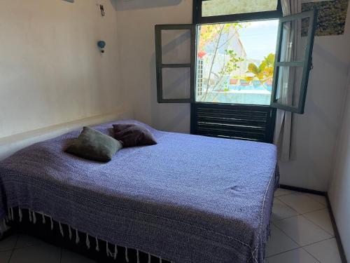 a bedroom with a bed and a window at Santo Antônio Além do Carmo - apartamento com varanda e vista pro mar, até 3 pessoas in Salvador