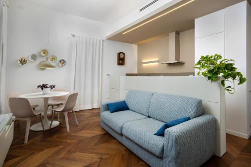 a living room with a blue couch and a table at La Casa sui Colli in Bologna