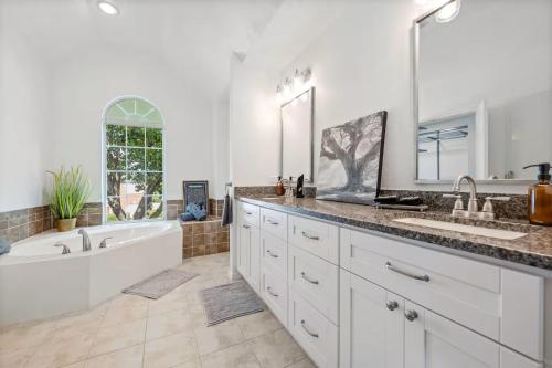 a bathroom with a tub and a sink and a tub and a bath tub at Meadow Park in Allen