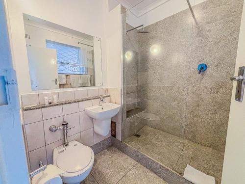 ein Badezimmer mit Toilette, Waschbecken und Dusche in der Unterkunft Baines Bed & Breakfast in Harare
