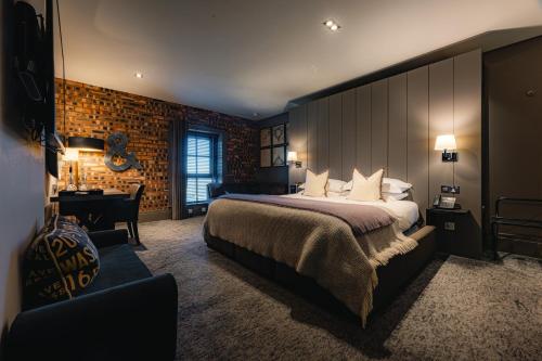a bedroom with a large bed and a desk at Dakota Edinburgh in Queensferry