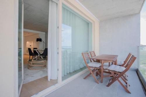 a table and chairs on a balcony with a dining room at Liiiving in Gaia - Beach Seaside Apartment in Vila Nova de Gaia