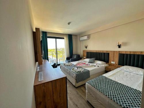 a room with two beds and a living room at Kaya Garden Side in Side