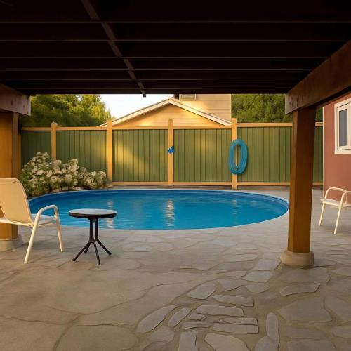 a swimming pool with chairs and a table in a patio at Poolside Hideaway Heated Pool All Year Ideal for Groups Sleeps 6 plus in Victoria