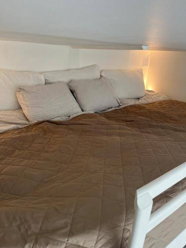a large bed with pillows on top of it at Exclusive 1 bedroom apartment in Copenhagen