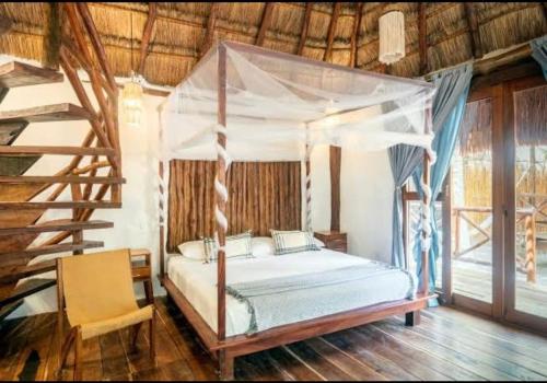 ein Schlafzimmer mit Himmelbett und Treppe in der Unterkunft Eco Cabañas Laak in Holbox