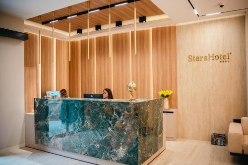 a woman is sitting at a desk in a lobby at Stars Hotel in Jelah