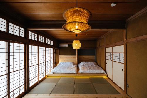 a room with a bed in a room with windows at 松本市の一棟貸しのプライベート邸宅 in Matsumoto