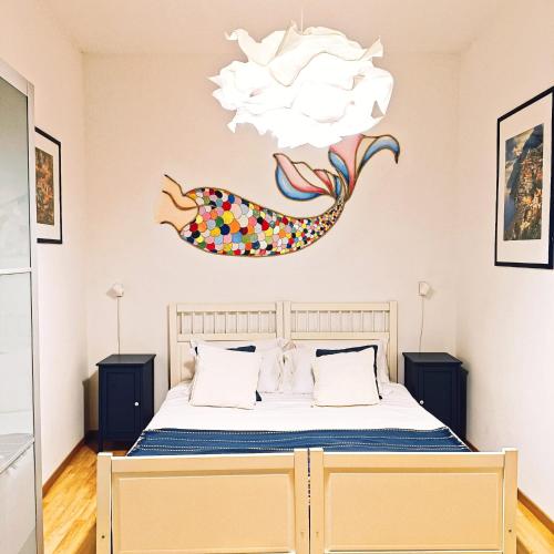 a bedroom with a bed with a fish on the wall at Agora Apartments -Friend's House Sorrento in Sorrento