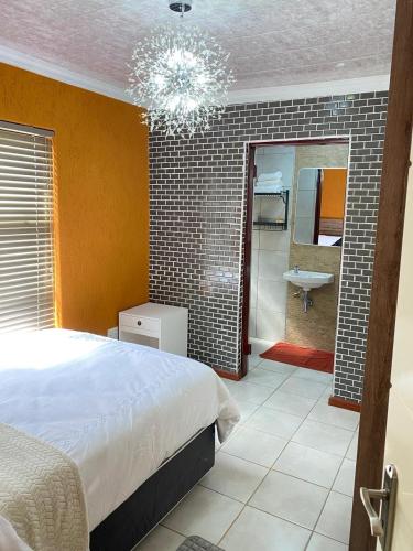 a bedroom with a bed and a bathroom with a sink at 26 Rubens apartments in Secunda