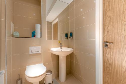 a small bathroom with a toilet and a sink at Charming 1Bed Flat with Private Balcony, Super Double Bed, Free Allocated Parking, and Easy Access to Tube & Central London in Enfield