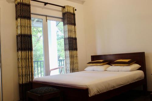 a bedroom with a bed and a large window at Kadulla Resort in Habarana