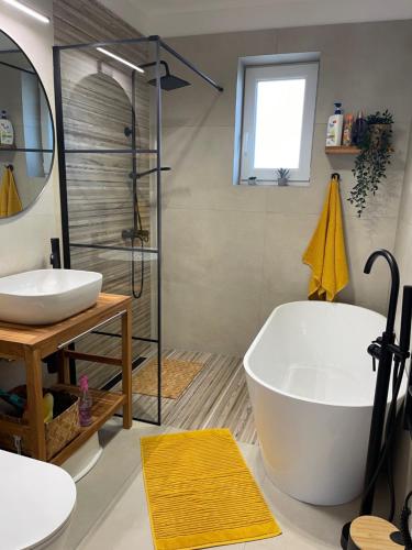a bathroom with a tub and a sink and a shower at Angyalkert in Balatonszárszó