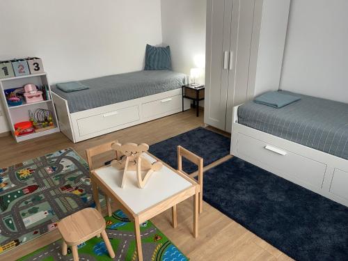 a small room with two beds and a table and chairs at Angyalkert in Balatonszárszó