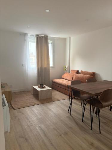 a living room with a couch and a table at Charmant Appartement Moderne B in La Roche-sur-Yon