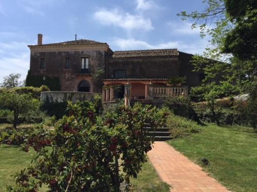 an old house with a brick path in front of it at Independent accommodation on Etna in San Giovanni Montebello