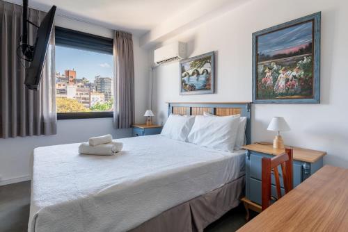 a bedroom with a bed and a table and a window at Lucas by Yoo por LikeHome in Auxiliadora