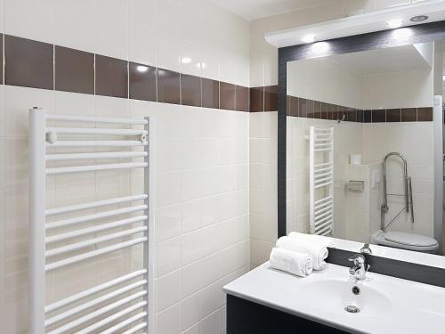 a bathroom with a sink and a mirror at Terres de France - Appart Hôtel Rouen Flaubert in Rouen