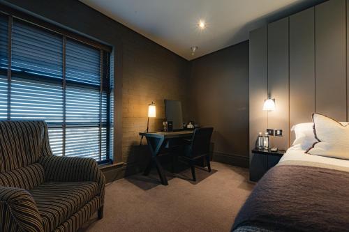 a bedroom with a bed and a desk and a chair at Dakota Edinburgh in Queensferry