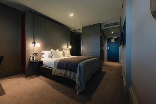 a bedroom with a large bed in a room at Dakota Edinburgh in Queensferry