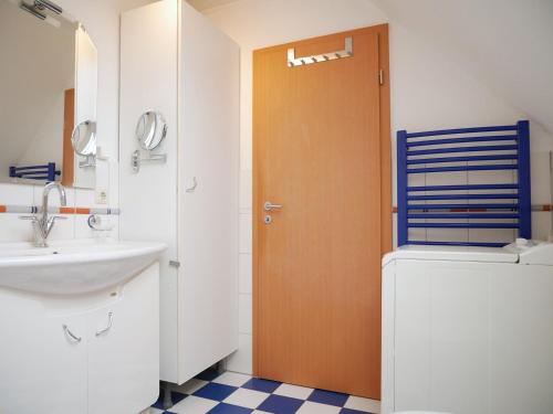 a bathroom with a sink and a wooden door at Robby2 in Kaltenhof